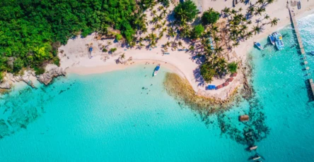 plage de sable blanc d'isla saona avec eau turquoise et bateaux, caraïbes
