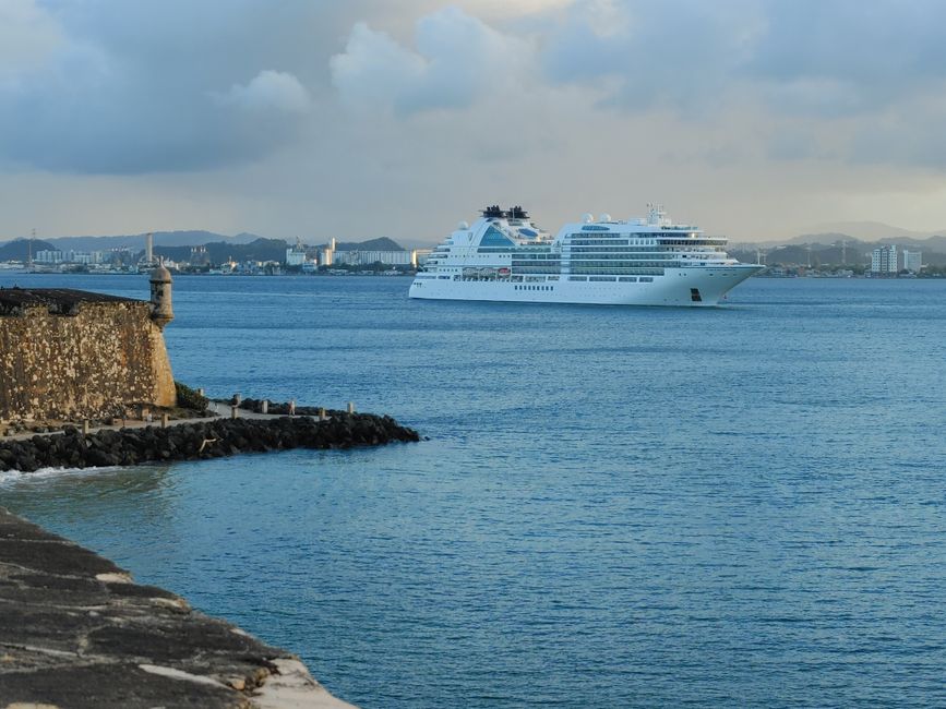 White cruise ship near historic San Juan fort, Puerto Rico at sunset.