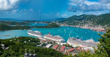 Aerial view of cruise ships docked in Charlotte Amalie Bay, Virgin Islands, under blue skies.